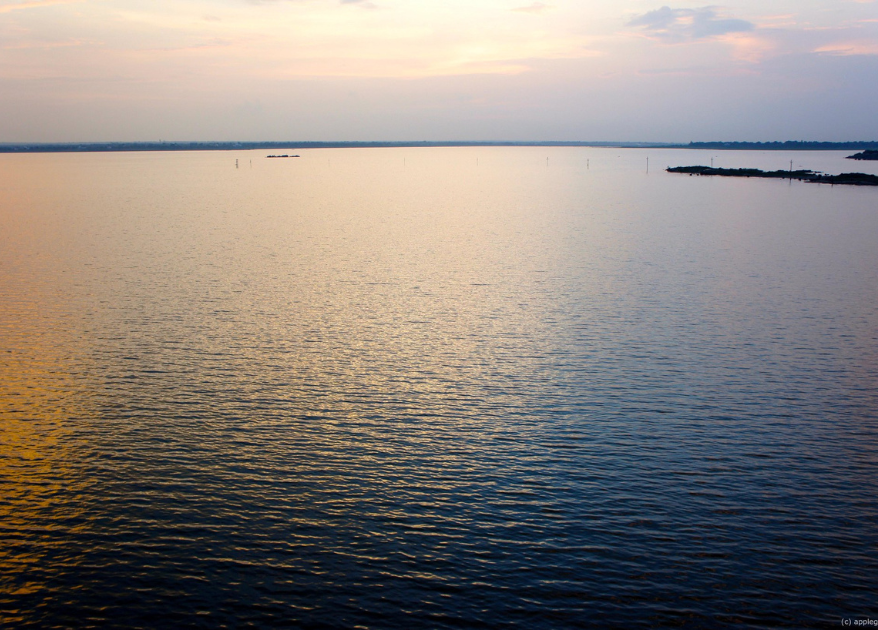 Breathtaking sunset over Osman Sagar Lake, painting the sky with vibrant colors.